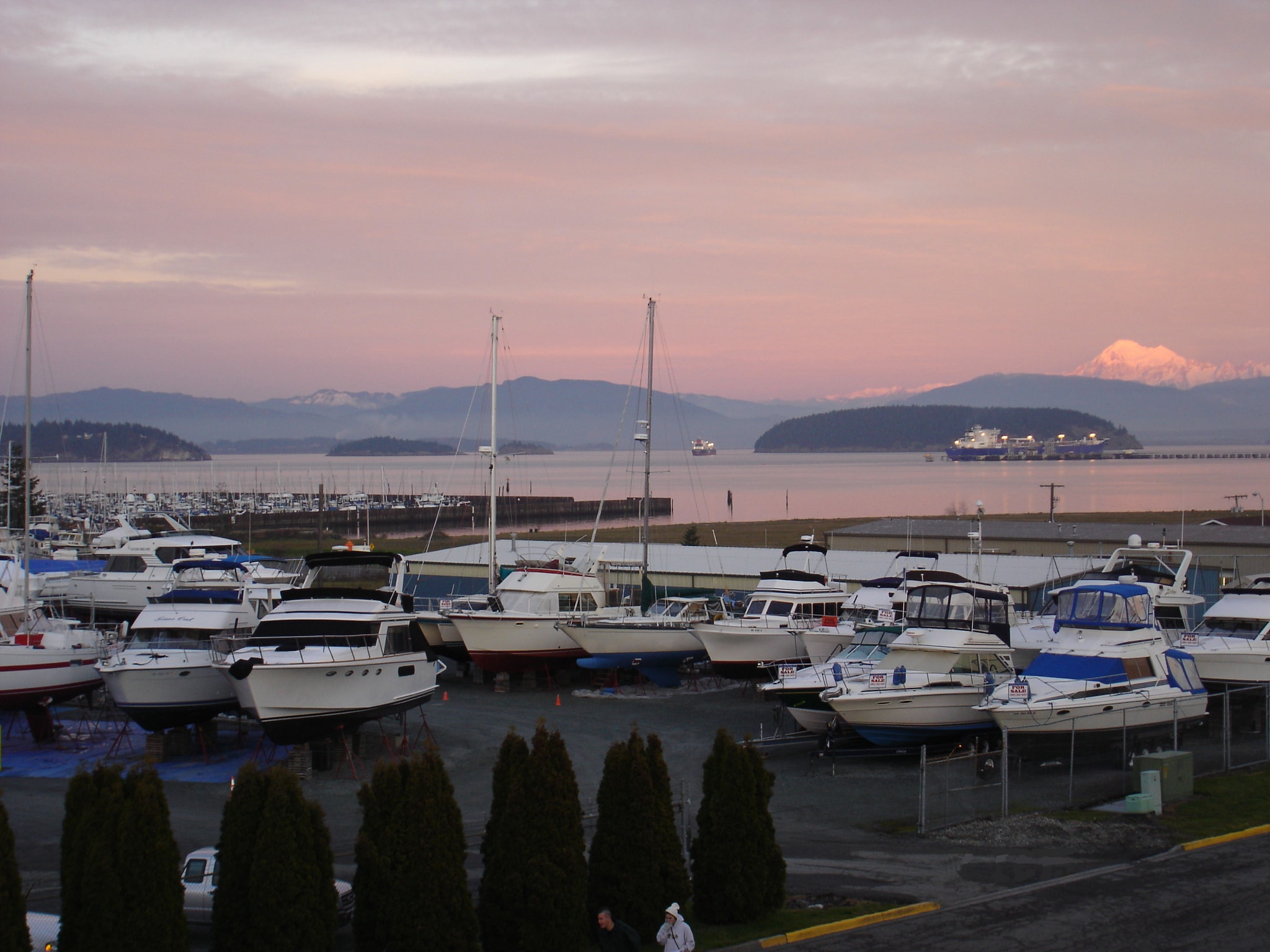 NHD boatyard at sunset with motor yachts and sailboats in dry storage, Puget Sound, San Juan Islands, and Mount Baker glowing pink in the background