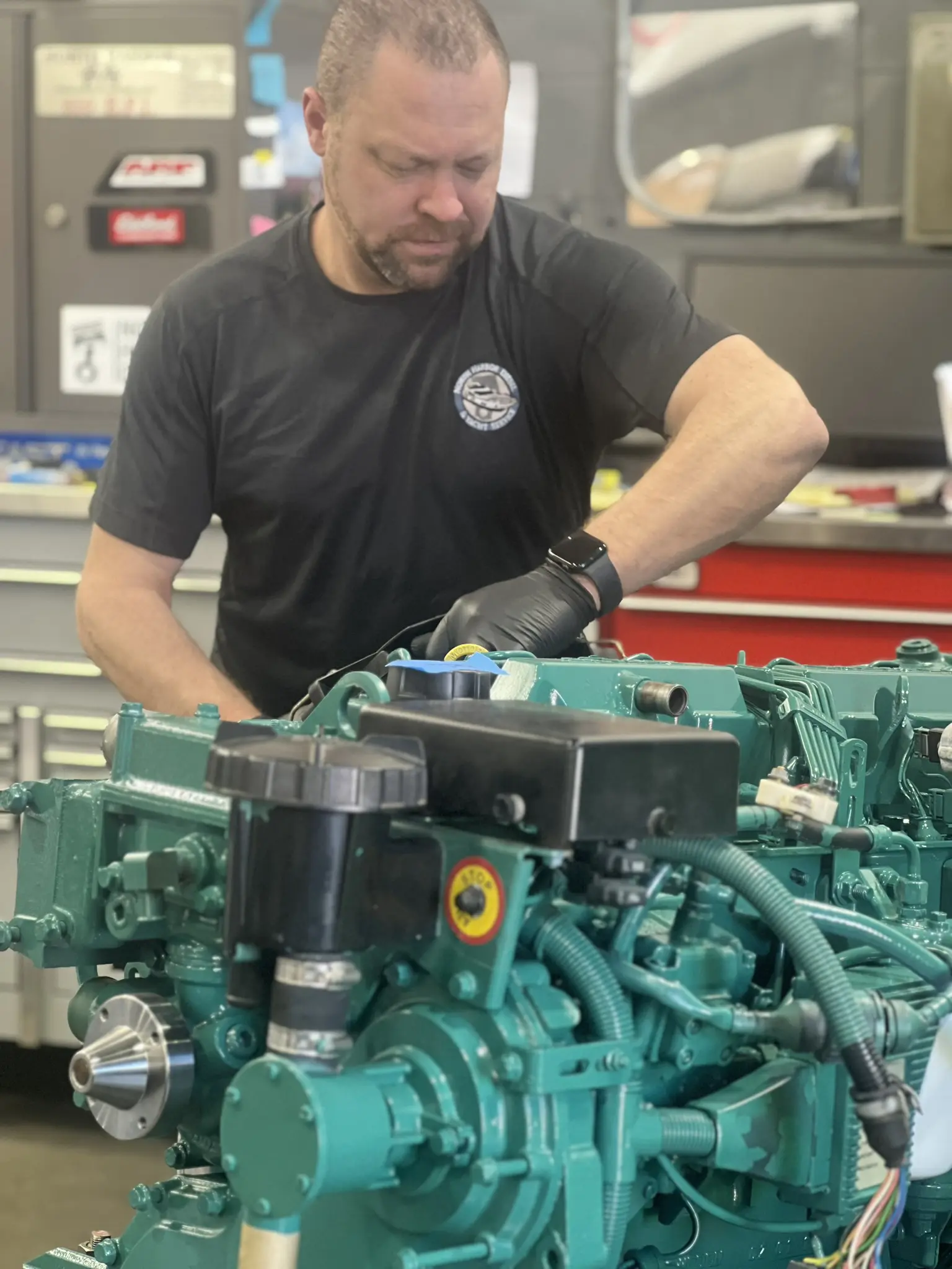 A man working on an engine in a garage.